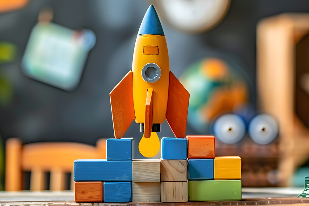 Wooden Building Blocks and Toy Rocket Represent Educational Entrepreneurship Kits for Children description This image depicts a playful and
